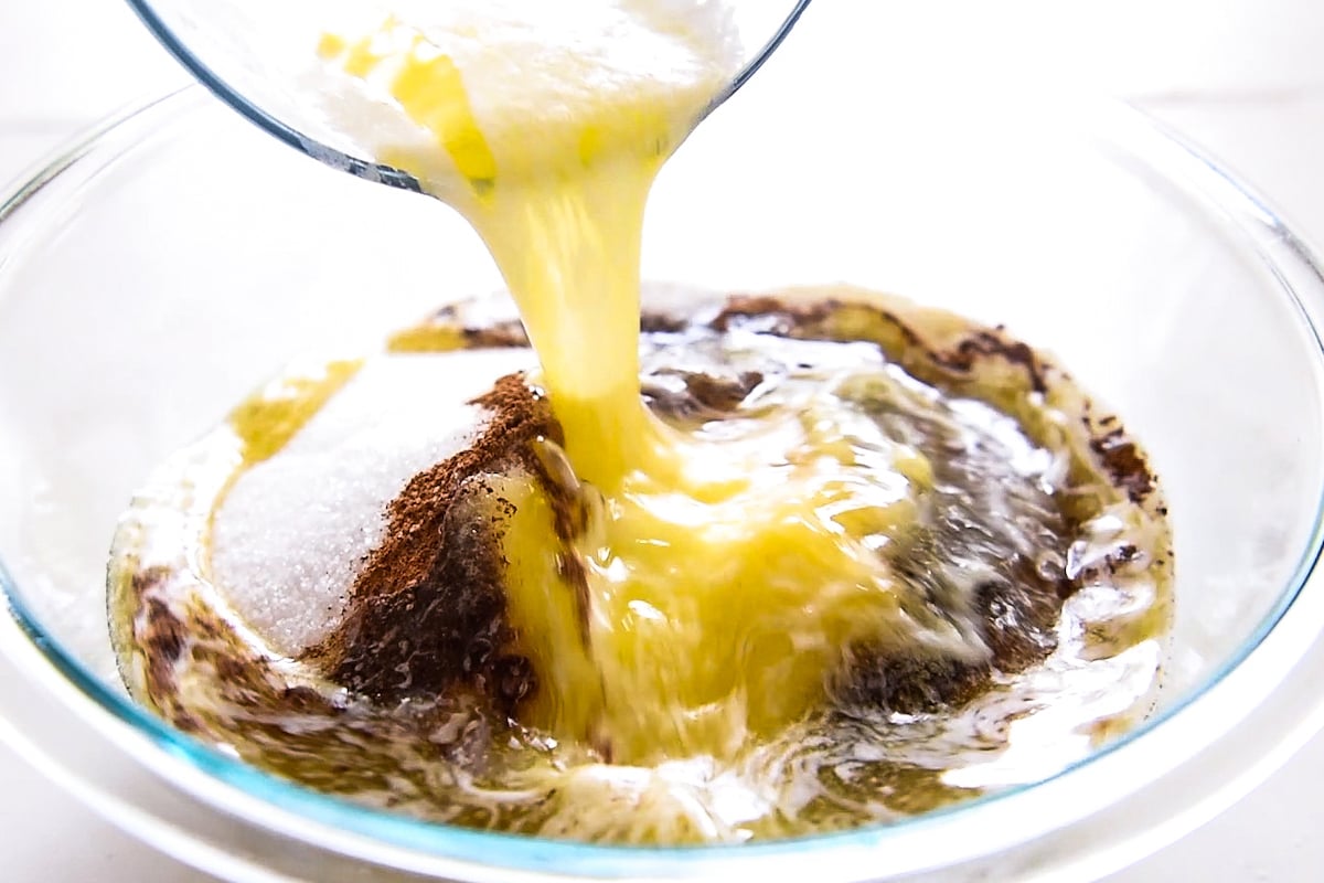 Butter being poured into a bowl with sugar, cinnamon and flour.