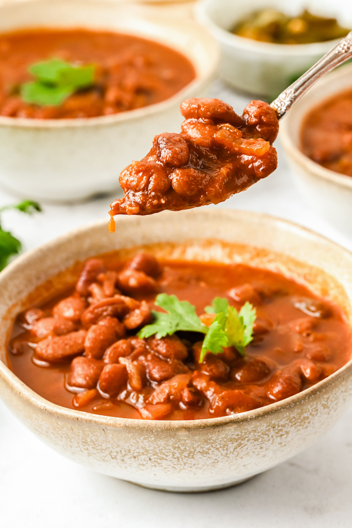 Spoonful of ranch-style beans over a bowl.
