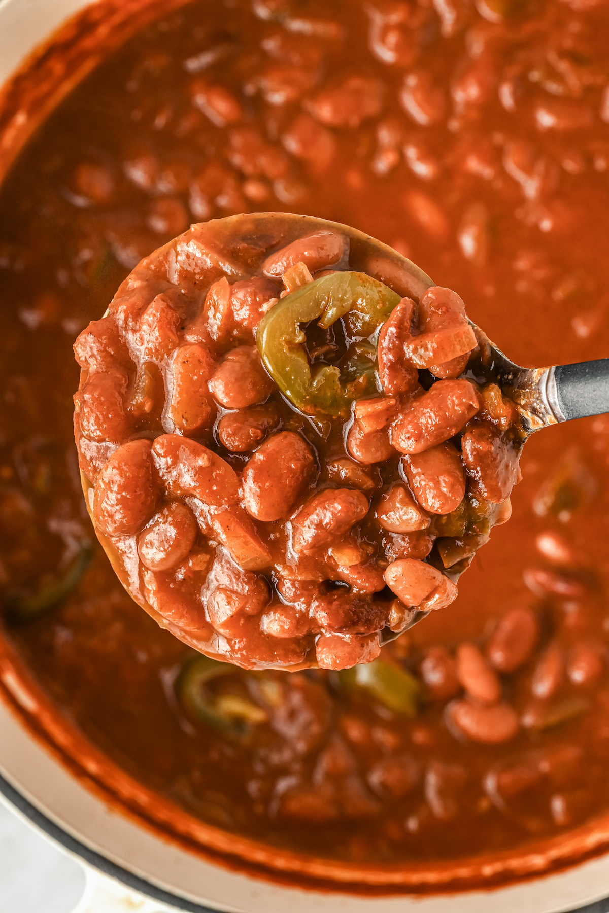 Close-up of ranch-style beans with a slice of jalapeño.
