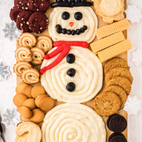 Snowman buttercream board with assorted cookies for dipping.