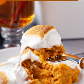 A serving of sweet potato casserole on a plate with a fork scooping up a bite.