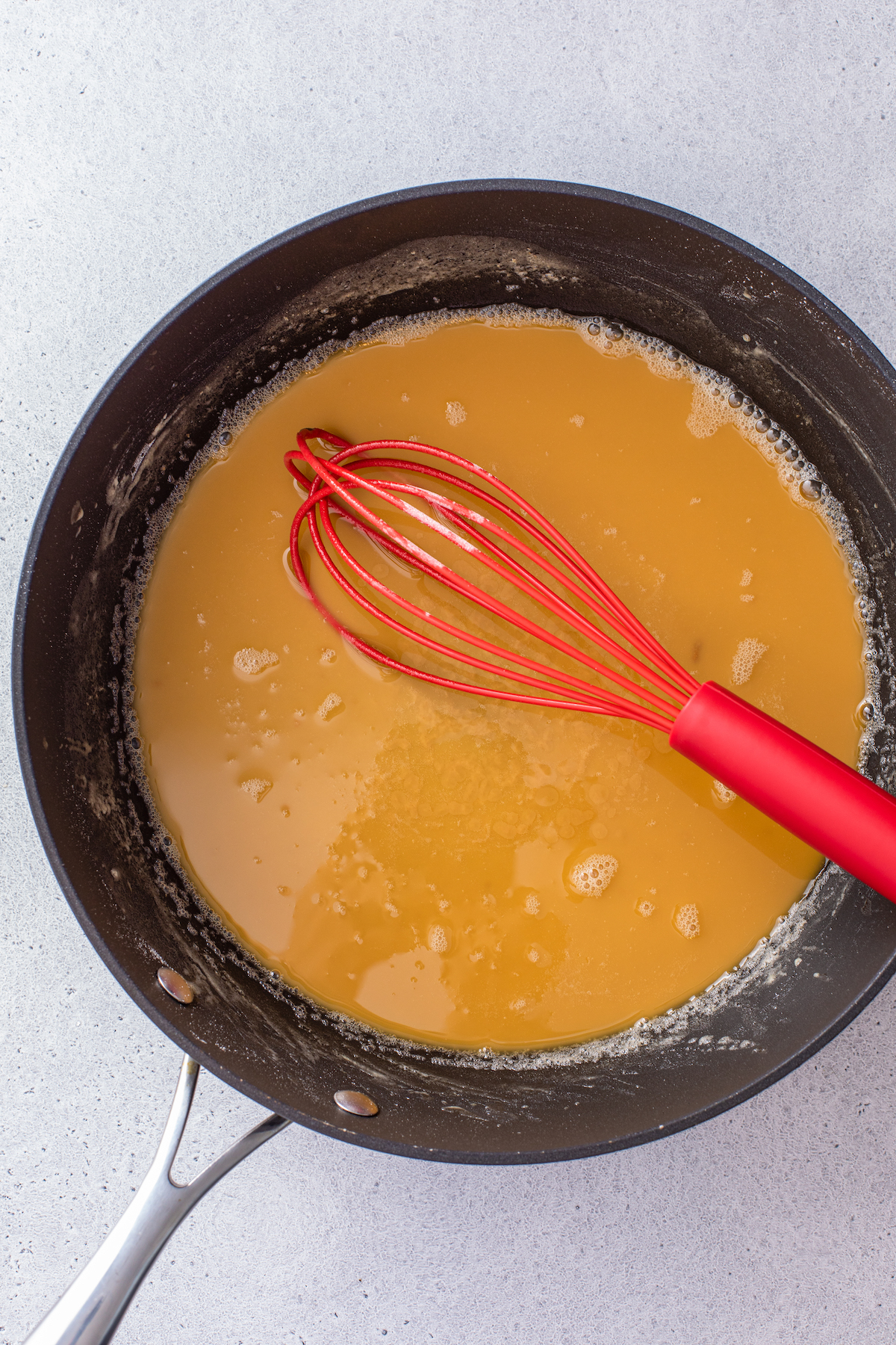 Whisking a roux in a skillet.