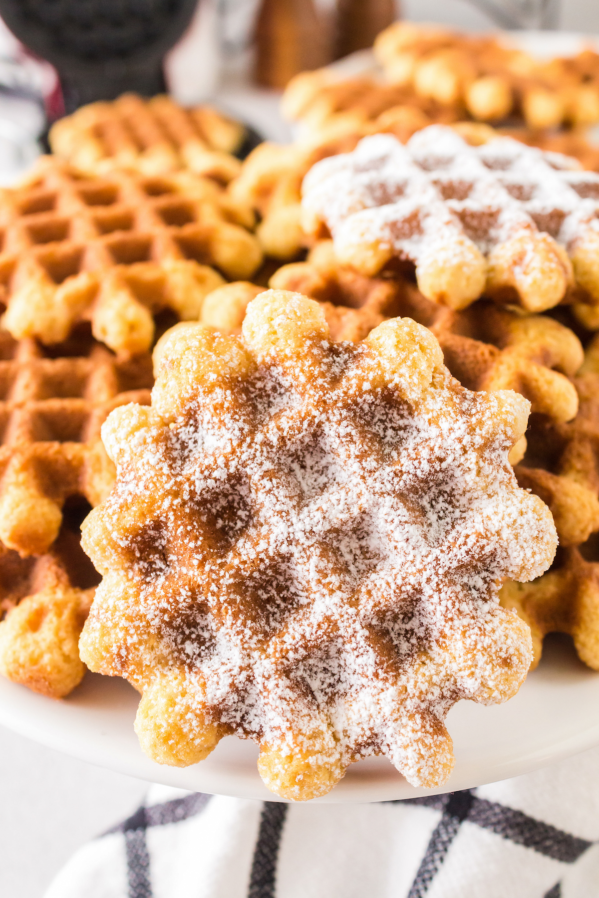 Close-up of waffle cookies dusted with powdered sugar.