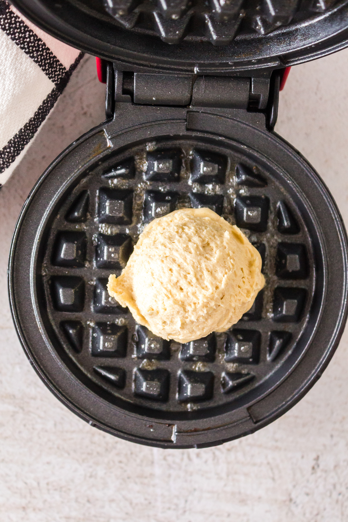 Scooping batter into the waffle iron.