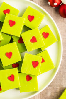 A white platter of green-tinted candy with red hearts.