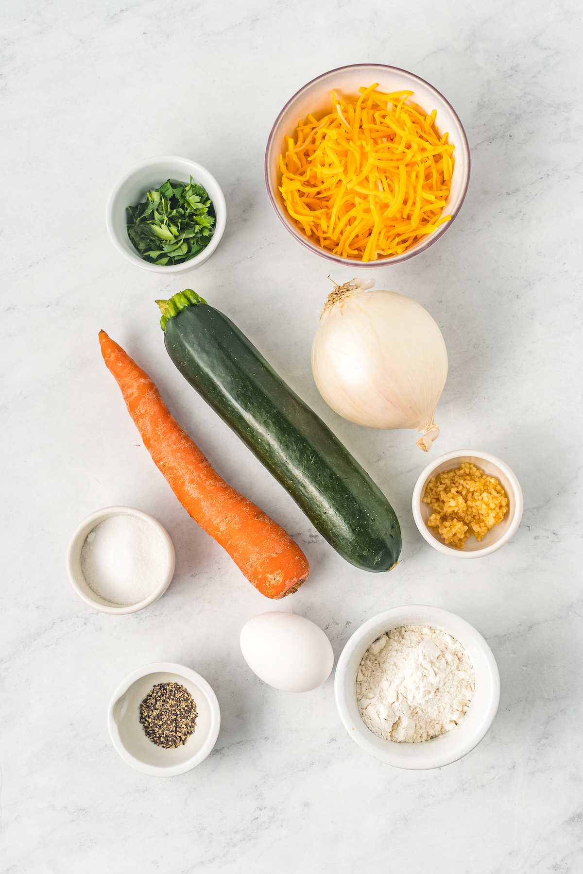 From top: Parsley, cheddar cheese, carrot, zucchini, onion, salt, egg, garlic, pepper, flour.