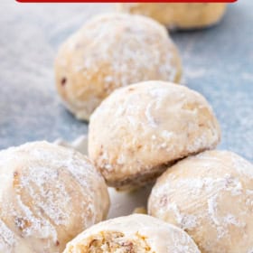 Almond cookies on a plate with a bite taken out of a cookie.