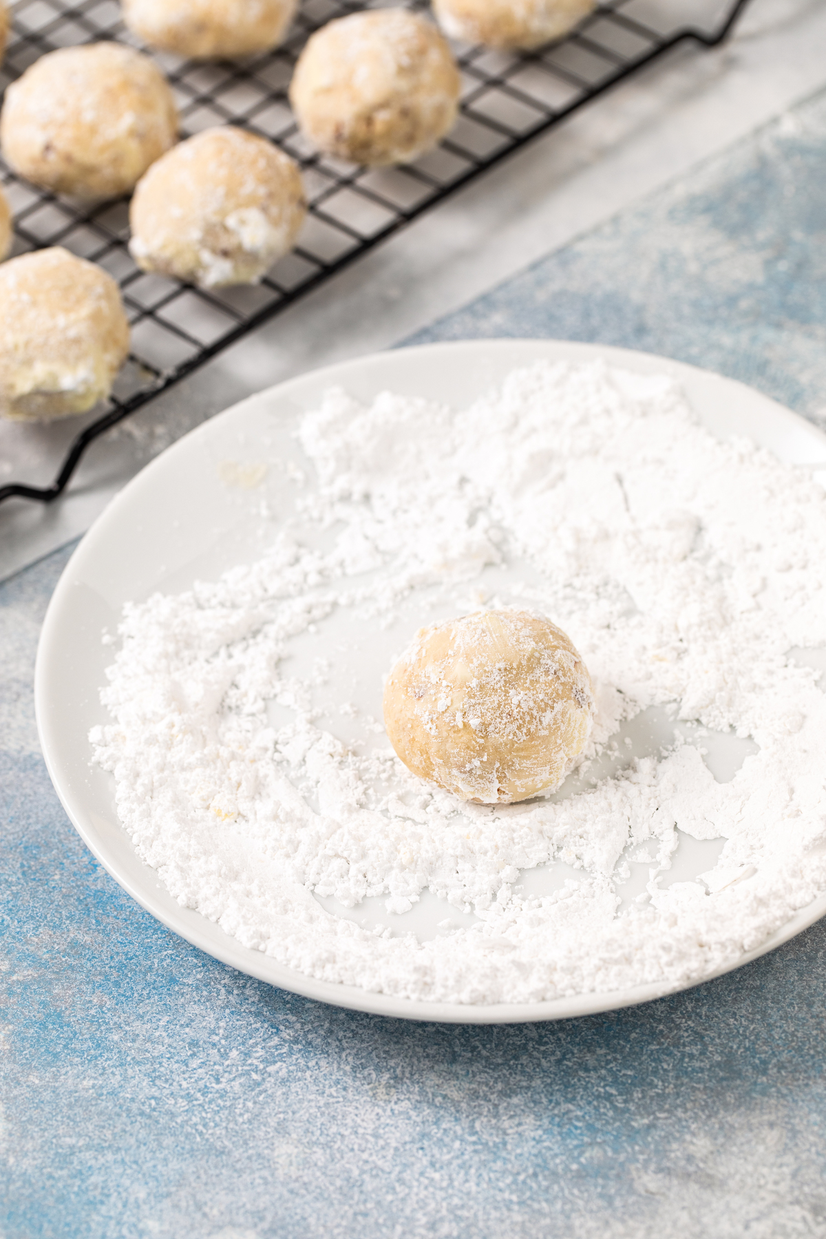A cookie being coated in powdered sugar.
