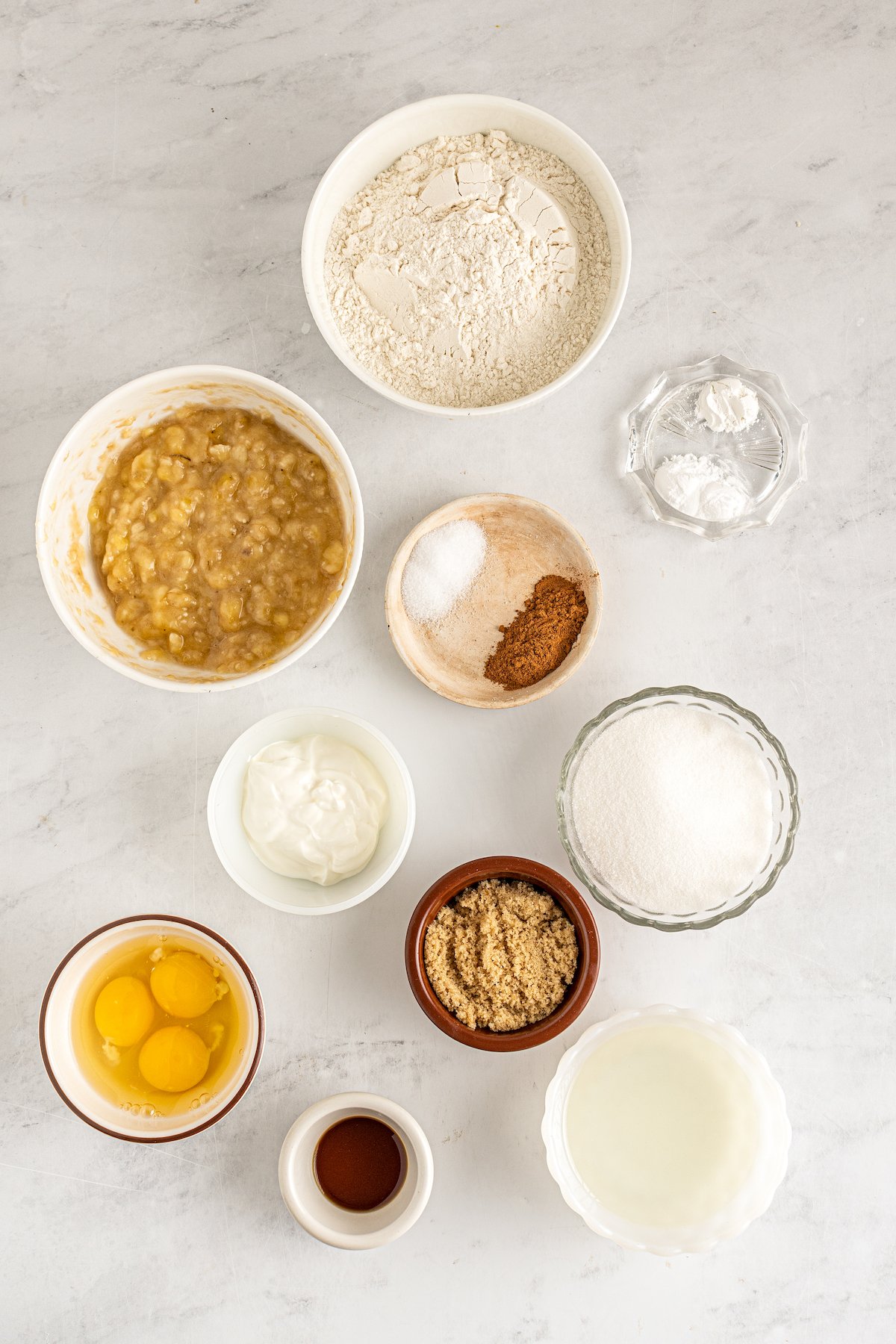From top: Flour, baking soda, baking powder, mashed banana, salt, cinnamon, sugar, sour cream, brown sugar, eggs, vanilla, oil.