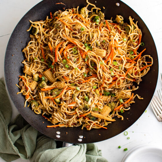 A skillet of pan-fried noodles with beef and veggies.