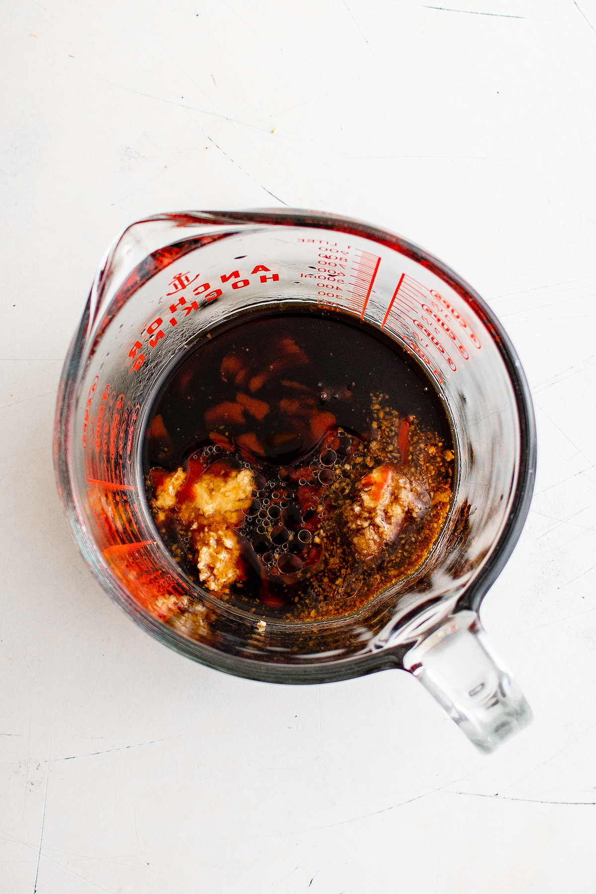 A large measuring cup with soy sauce and other ingredients mixed in it.