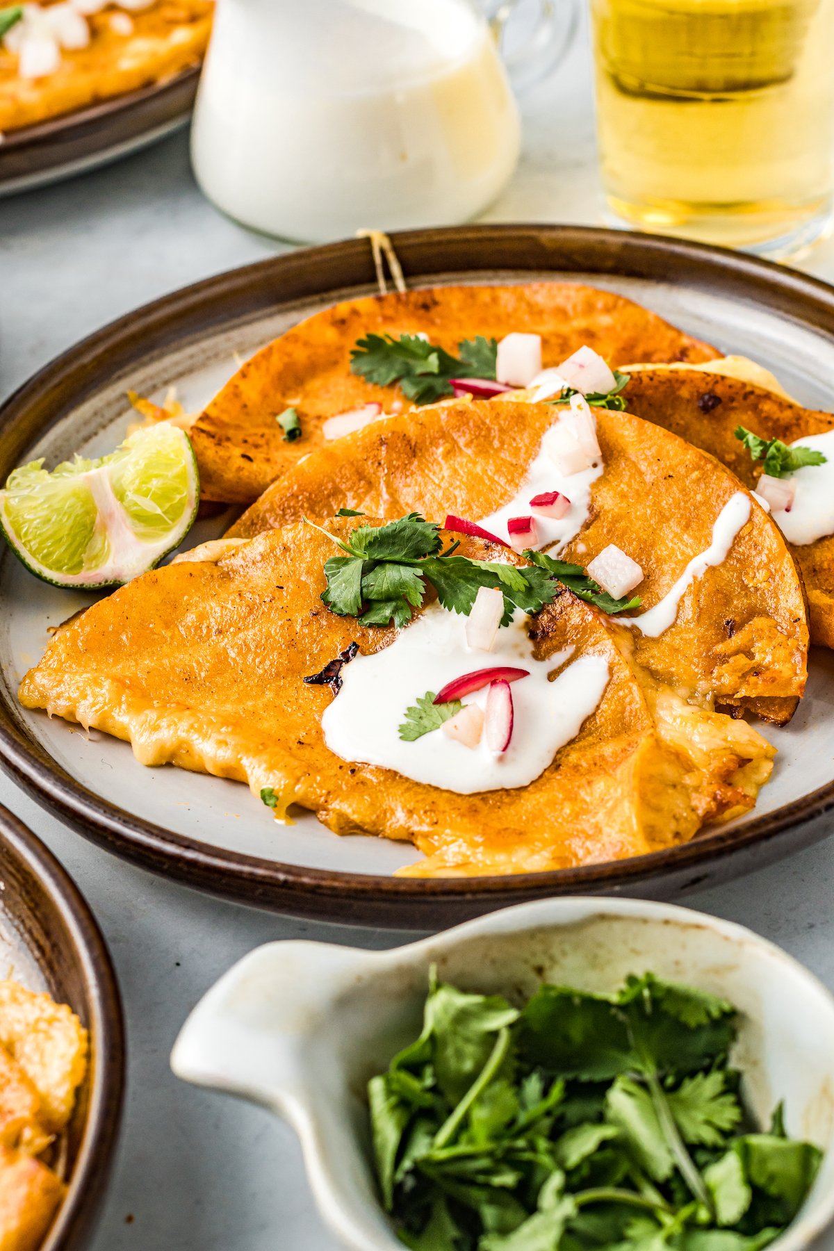 Tacos de birria with crema, cilantro, and radishes.