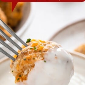 A bowl of sausage balls and a sausage ball being dipped into white gravy.