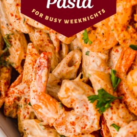 Cajun shrimp pasta with red seasoning sprinkled on top.