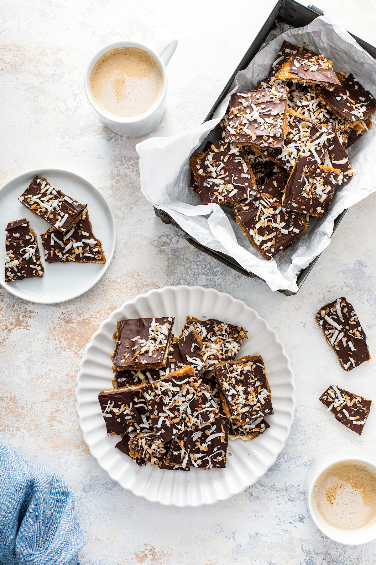 A plate with coconut christmas crack and two cups of coffee.