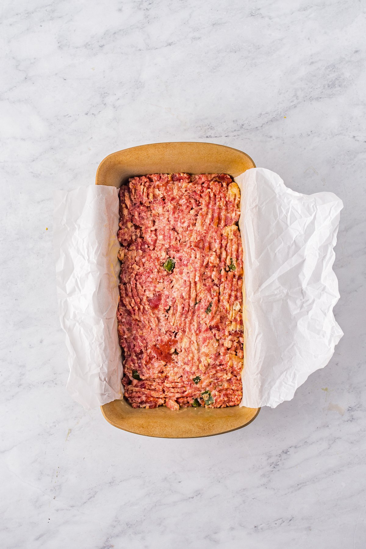 A ground beef mixture pressed into a loaf pan.