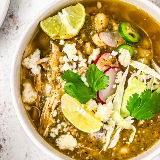 Landscape photo of Mexican pozole with toppings.