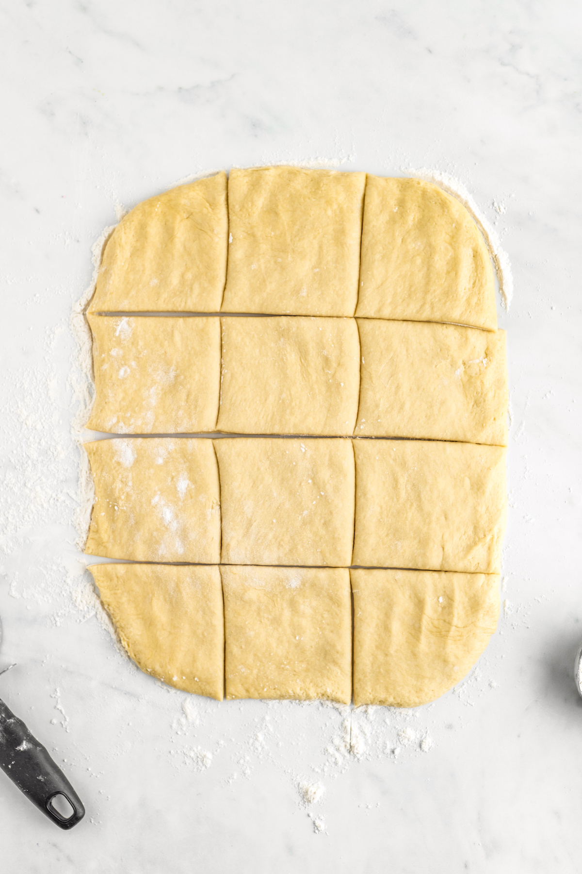 A rectangle of soft dough cut into 12 pieces.