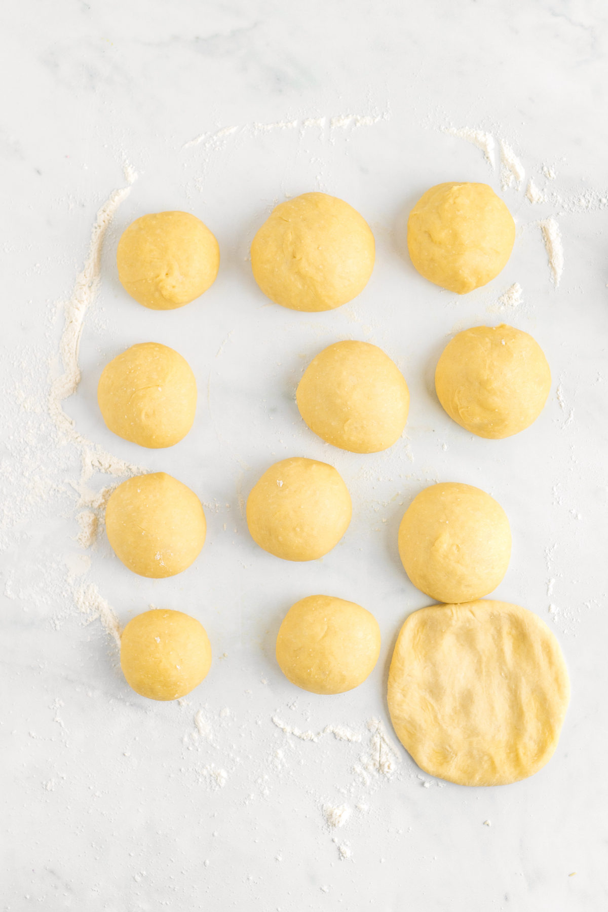 Flattening risen yeast rolls.