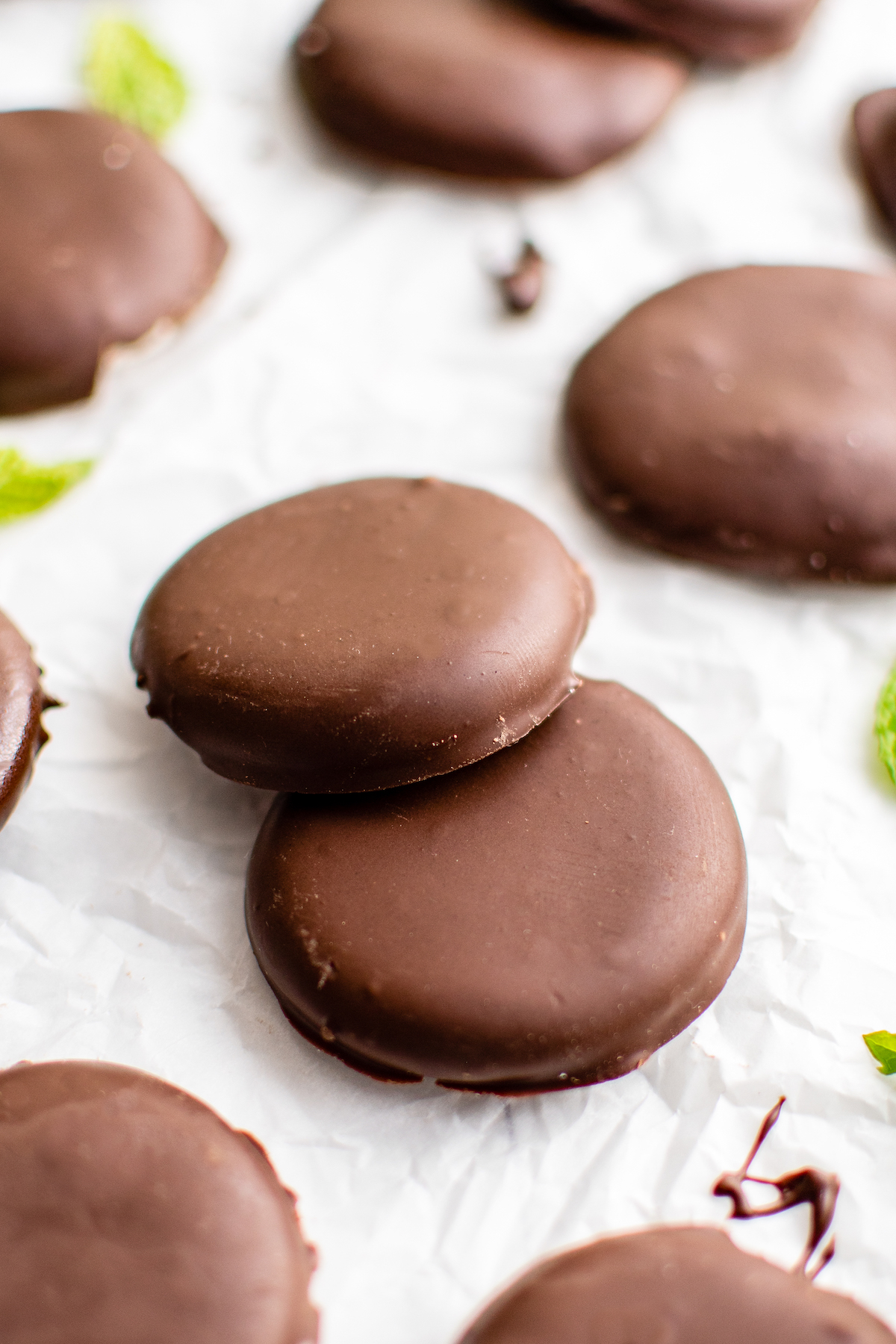 Homemade peppermint patties garnished with mint leaves.