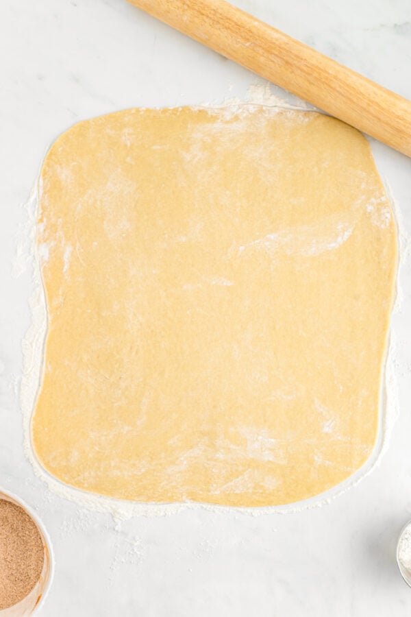 A rectangle of thinly-rolled yeast dough on a work surface.