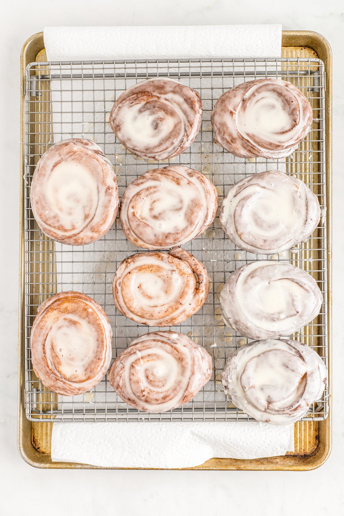 Glazed sweet rolls on a baking sheet.