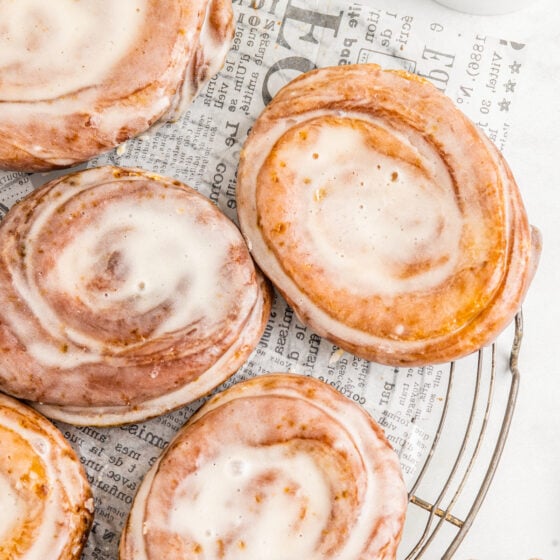 Glazed honey buns on a wire serving platter lined with parchment.
