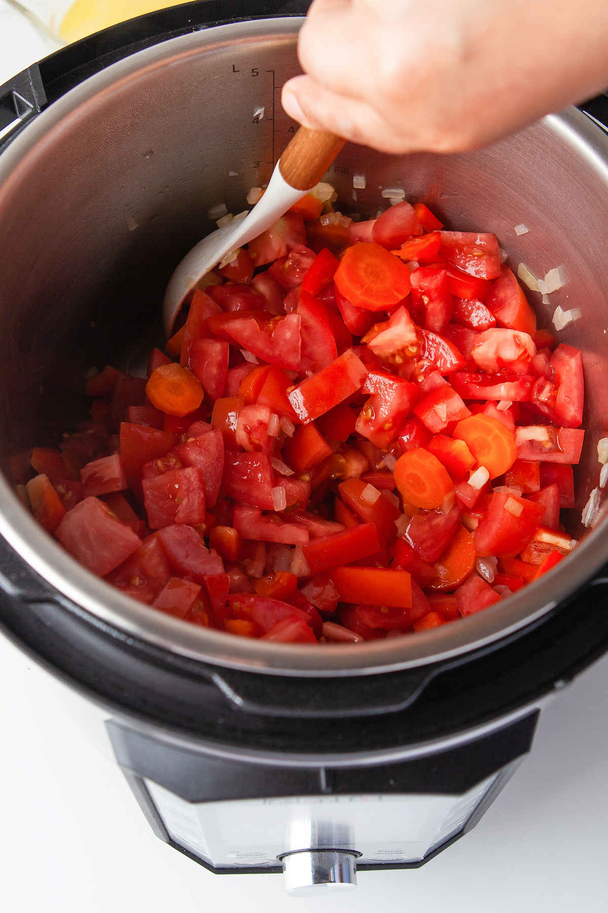 Stirring tomato soup ingredients.