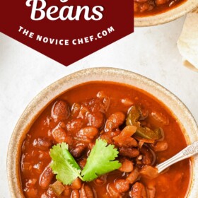 A bowl of ranch style beans with a spoon and cilantro on top.
