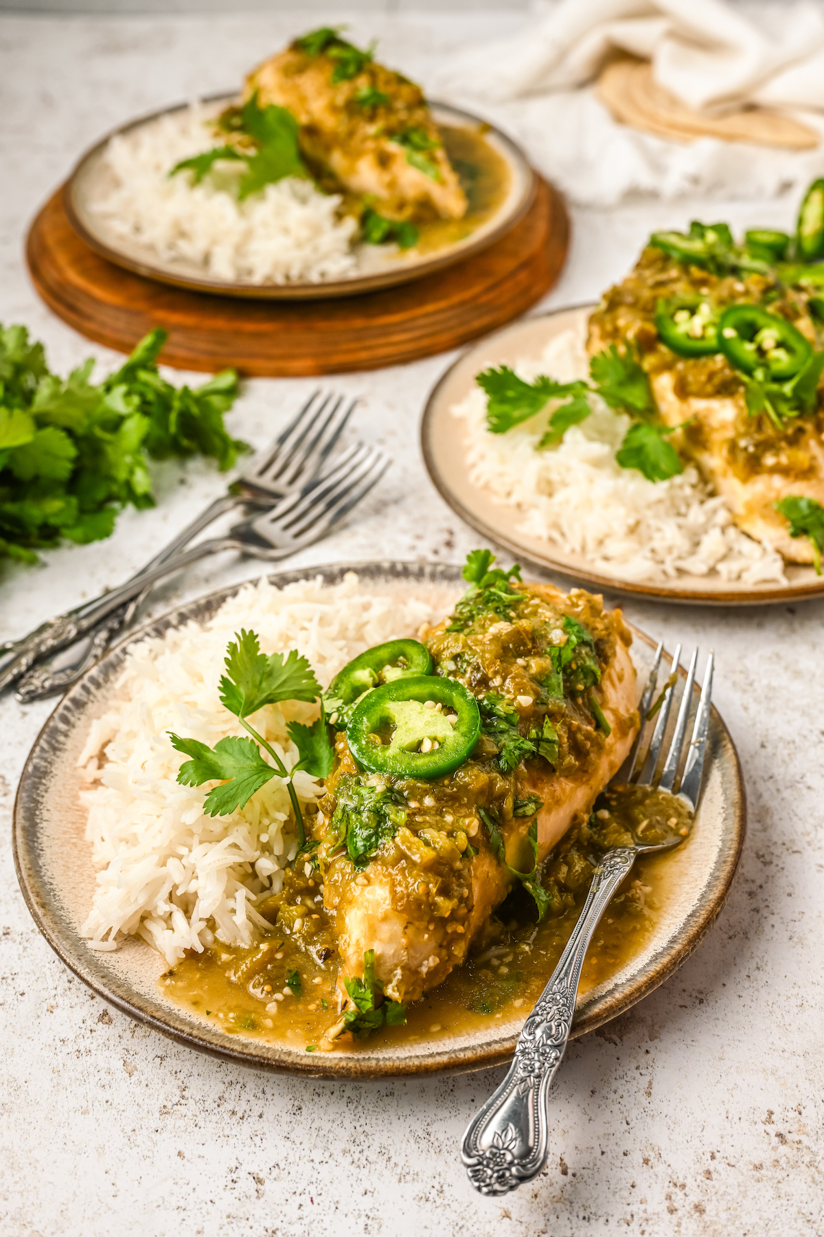 Three plates of easy salsa verde chicken with white rice.