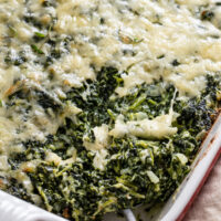 A spoon scooping up a serving of spinach casserole.