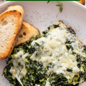 Cheesy spinach casserole on a plate with a fork.