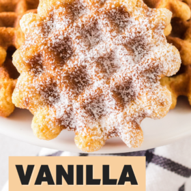 Waffle cookies stacked on a plate and dusted with powdered sugar.