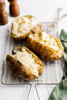 Baked potatoes split and fluffed up with a fork.