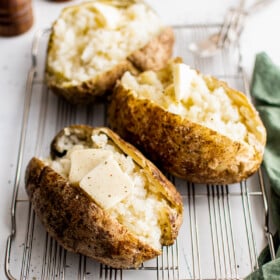 Baked potatoes split and fluffed up with a fork.