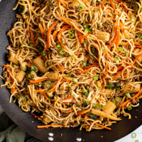 A wok filled with pan fried noodles with vegetables and beef.