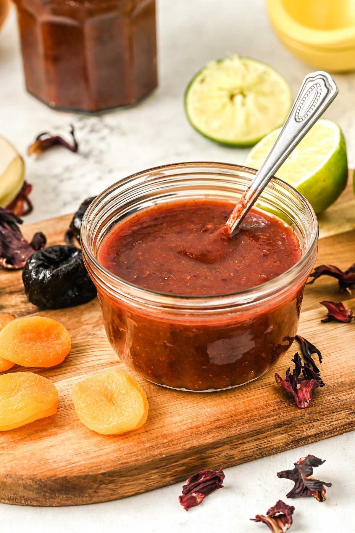 Homemade chamoy in a glass container with a spoon.