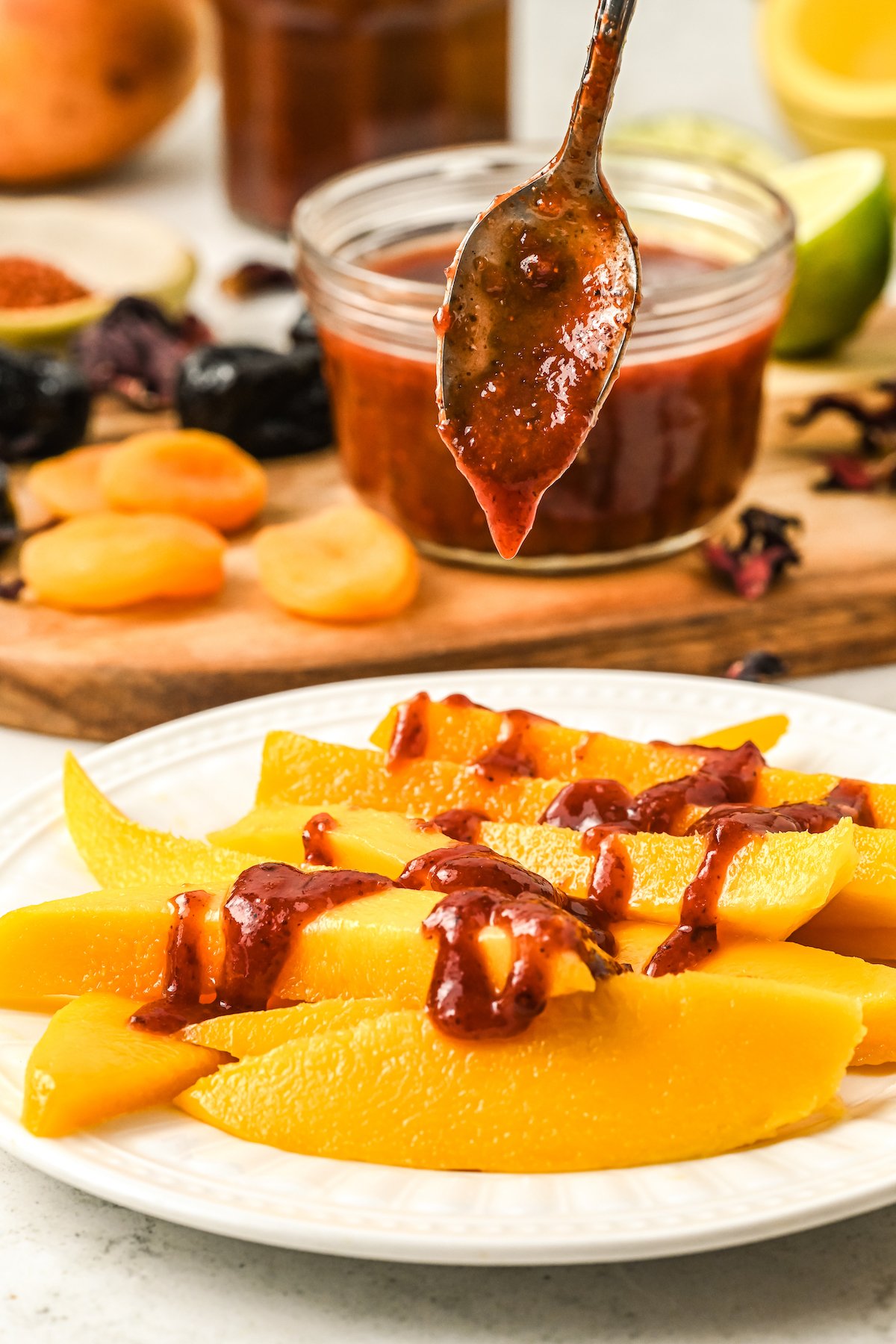 Drizzling homemade chamoy over mango slices.