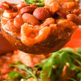 A spoonful of charro beans with jalapeno on top.
