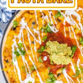 A skillet filled with Chicken Enchilada Pasta Bake topped with sour cream, cilantro, salsa and guacamole.