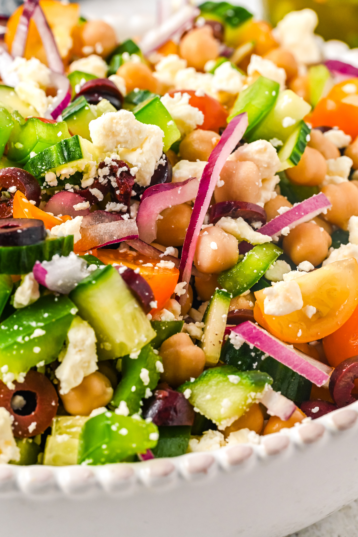 Close-up shot of vinaigrette-dressed salad with chickpeas.