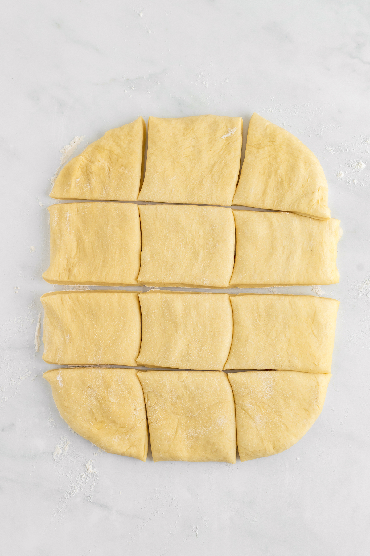 A rectangle of dough cut into twelve pieces.