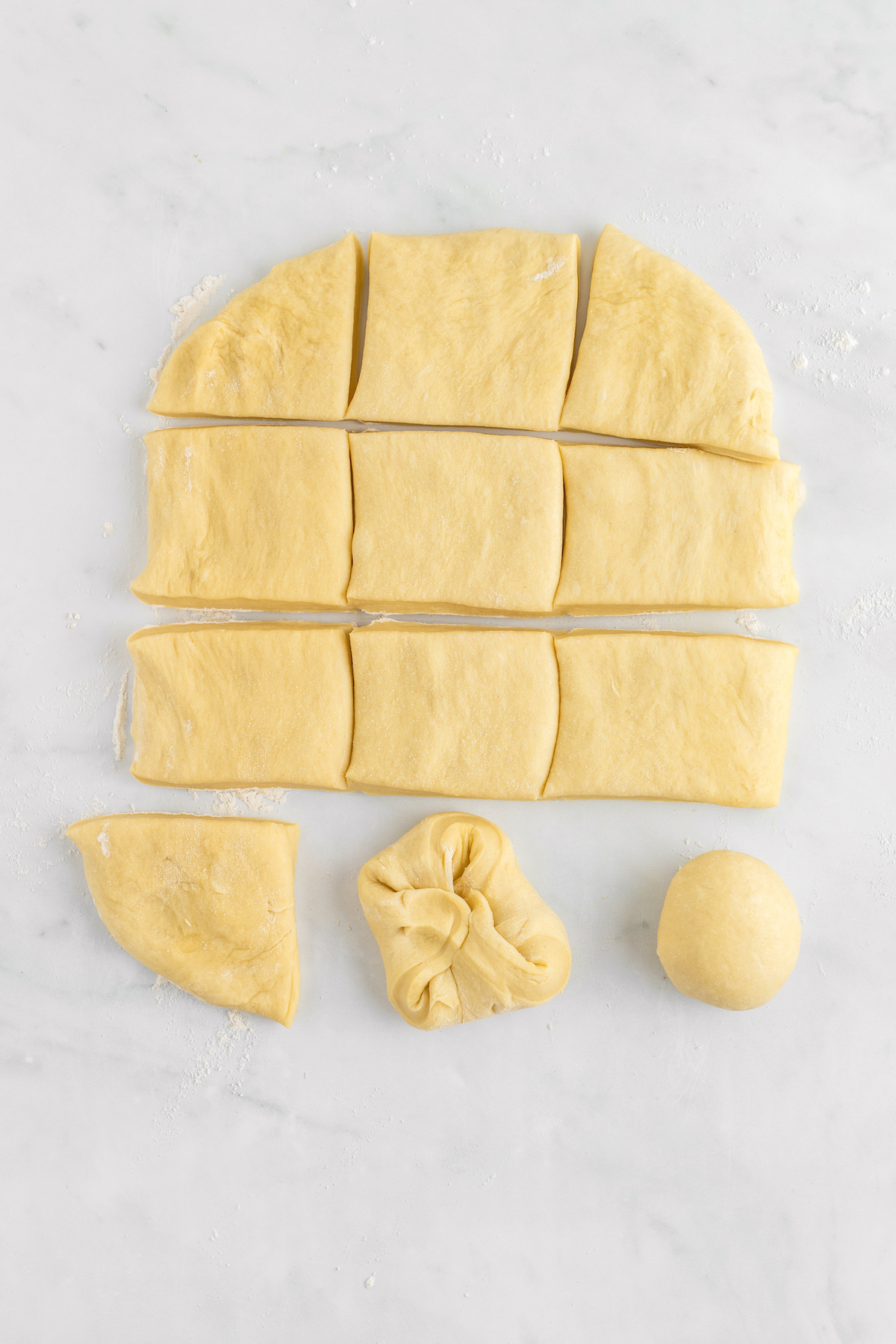 Folding squares of dough into rolls.