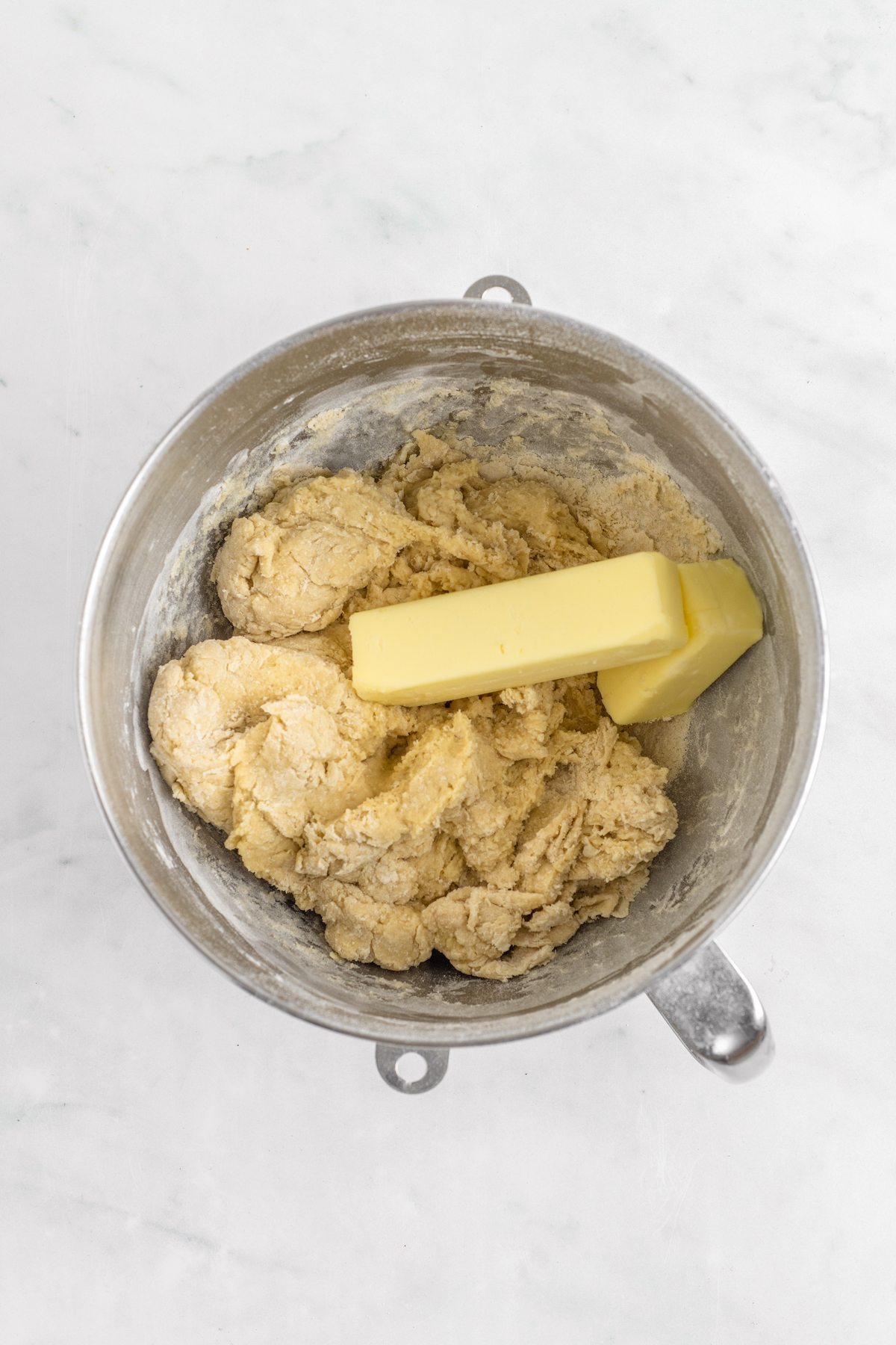 Butter added to a soft dough in a mixing bowl.