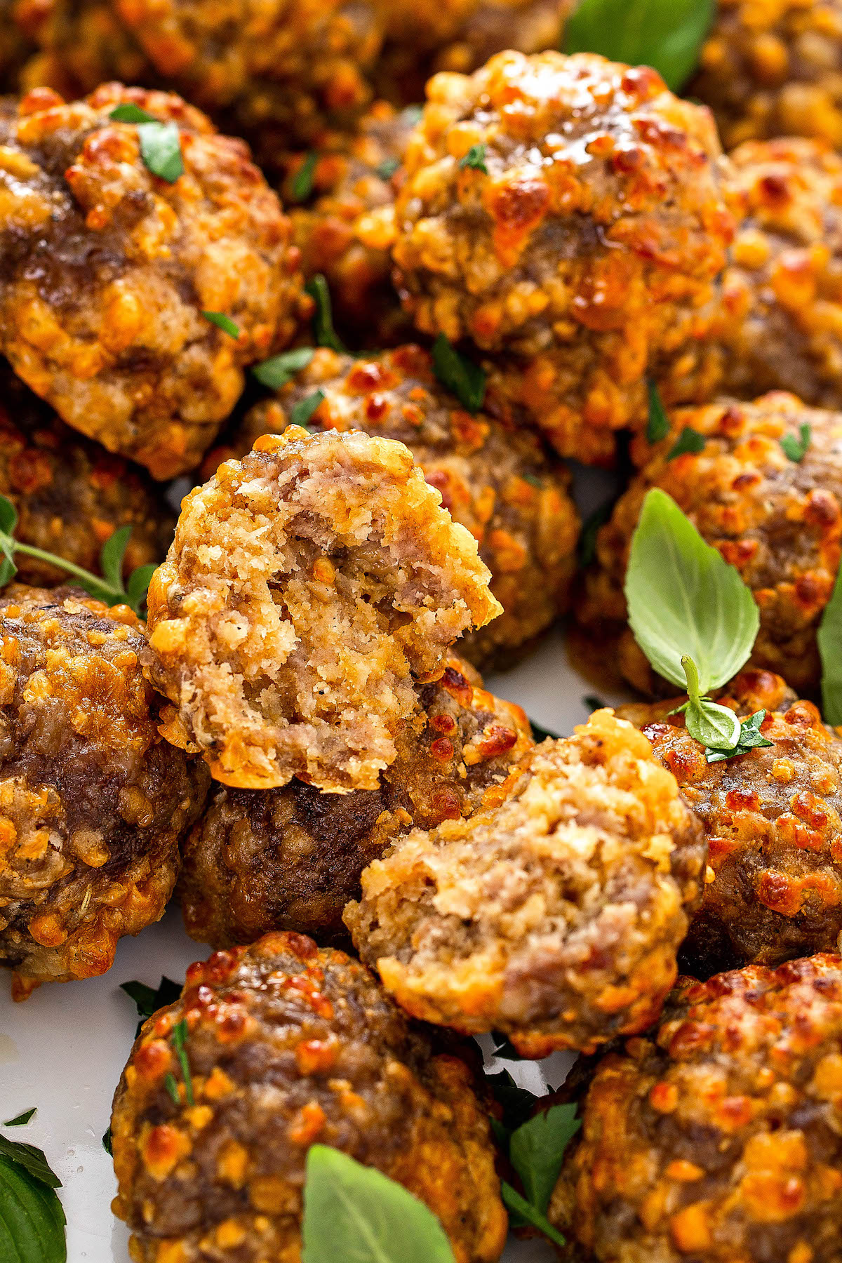 Bisquick sausage balls on a platter with one broken in half.