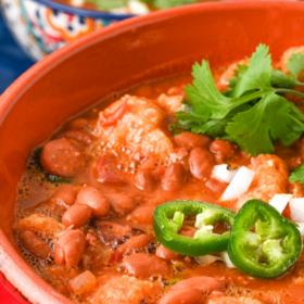 A pot of charro beans with jalapenos on top.