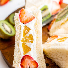 Close-up shot of a fruit sando made with fresh strawberries and orange sections to make a pattern.