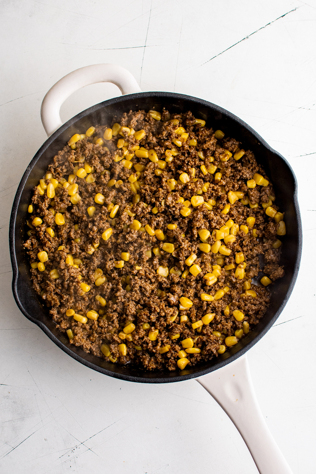 Ground beef, corn, and taco seasoning in a skillet.