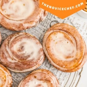 Honey buns on parchment paper on a cooling rack.