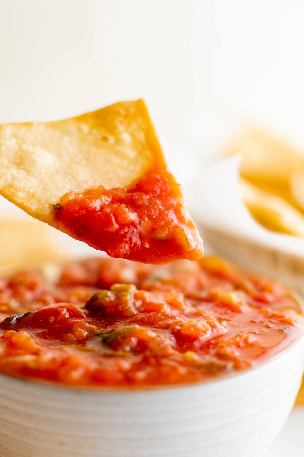 Dipping a corn tortilla chip into salsa.